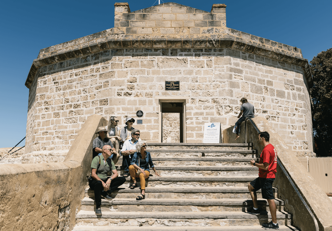 A Crimes of Fremantle group on the Round House steps with their guide in the red Two Feet shirt