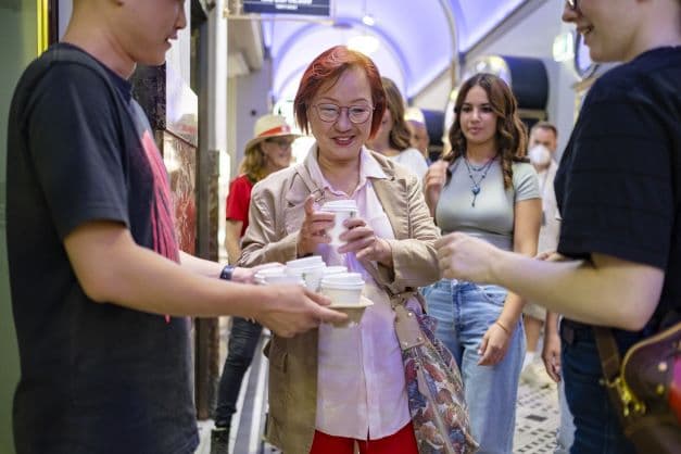 Guests handed takeaway coffees inside an ornate Perth arcade on a walking tour